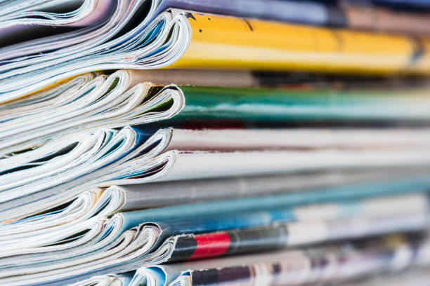istock Pile of magazine newspapers stacks on blur background 2062671212