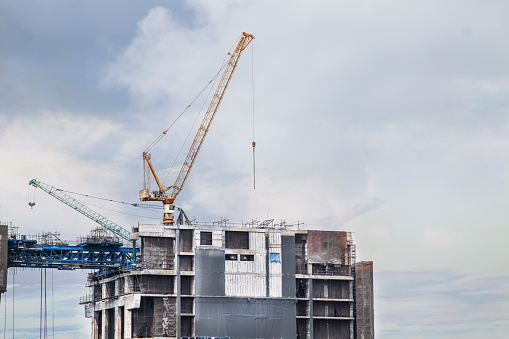 about the tower crane at some of the construction sites when sunset that is used for building the city town