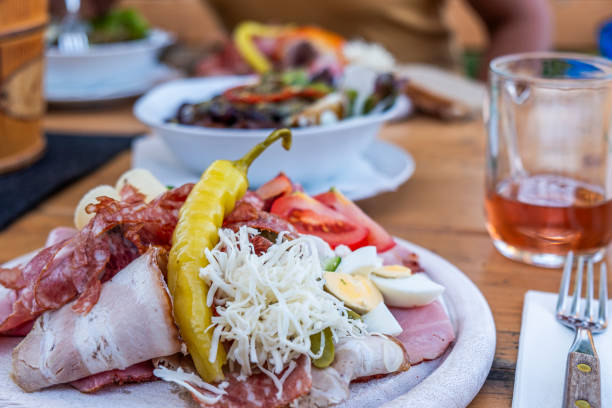 Brettljause, with meal, cheese, vegetable occupied bread traditional Styrian sandwich and a glass juice on wooden table in Austria