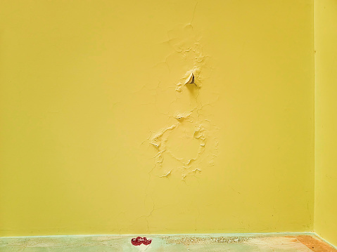 Yellow walls. There are cracks on the surface.
