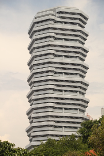 A skyscraper featuring various faces at its peak with modern architecture in Singapore
