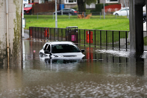 A white car submerged in water after flooding in Scotland.