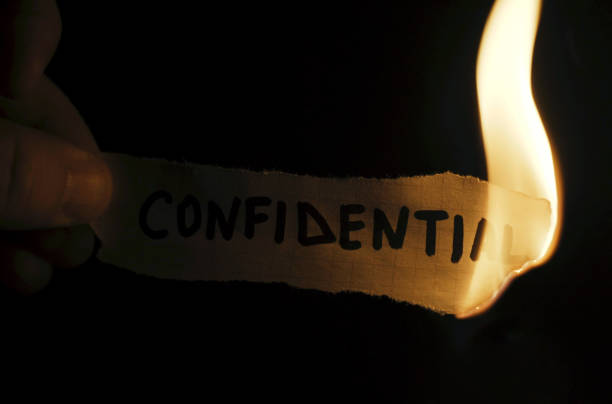 istock A man burns paper with the inscription - Confidential 2062754006