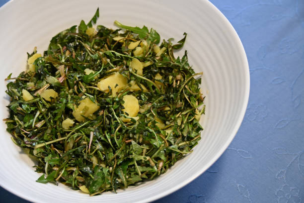 istock Dandelion salad with warm potatoes served on the table. 2062765216