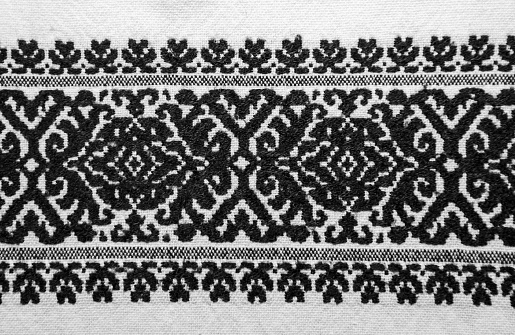 An embroidery (stitching) on a white cloth with traditional motifs