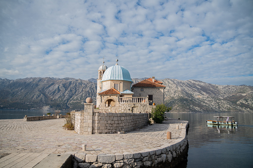 Perast, Montenegro – January 15, 2024: The Lady of the Rock Island in Perast, Montenegro, with magnificent mountain views from the wonderful Adriatic Sea