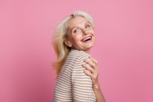 Photo of adorable cheeful glad lady dressed trendy clothes looking empty space banner isolated on pink color background.