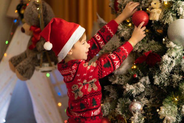 istock A little boy decorates the Christmas tree at home 2062821318