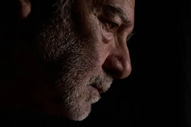 A profile portrait of a middle-aged man against a black background, AI-generated.