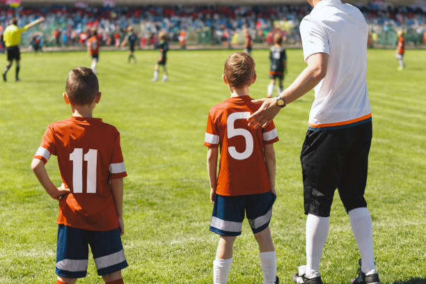 soccer substitution during children's soccer tournament. soccer team coach coaching the school team in a league game - soccer child coach childhood imagens e fotografias de stock