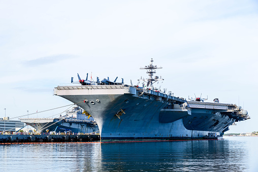 American aircraft carrier anchored in a harbour after offshore training exercises.