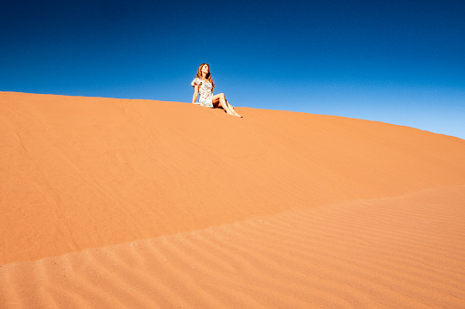 Woman sitting on the dunes in Sossusvlei, Namibia