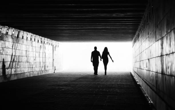 surreal tunnel of bright light with a shadowy figure at the end