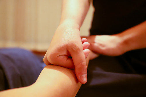 A masseur providing a hand massage to a client.