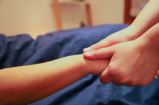 A masseur providing a hand massage to a client.