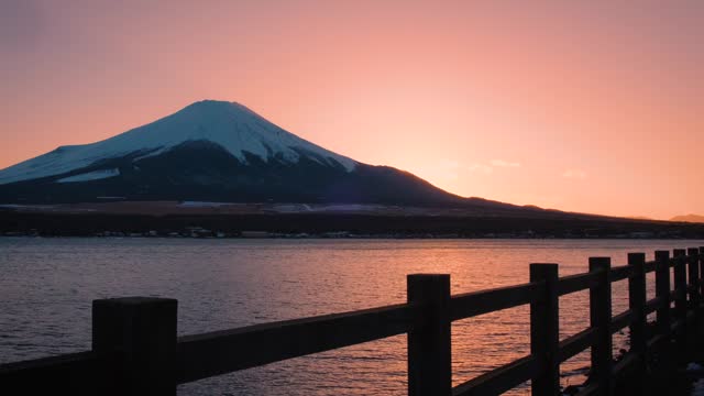 Mount Fuji during the twilight sky Sunset hits the mountains and reflects on Lake Kawaguchi, a landmark and destination for tourists and travelers. The beauty of nature in the peaceful evening