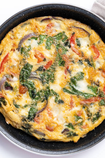istock Fritatta made with spinach, tomatoes, onion and peppers on marble background 2062901092