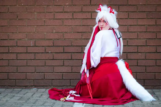 Female cosplayer in feline priestess attire at a convention
