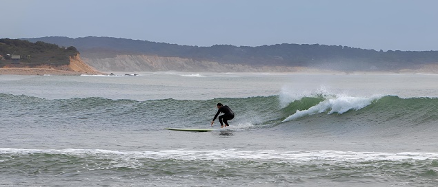 chilmark, United States – August 24, 2022: A surfer enjoying a late summer swell of big waves off the coast of Martha's Vineyard