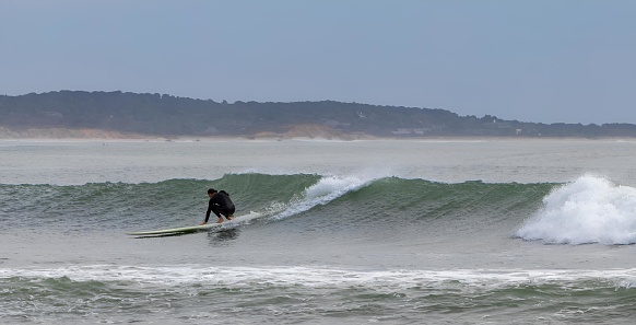 chilmark, United States – August 24, 2022: A surfer enjoying a late summer swell of big waves off the coast of Martha's Vineyard
