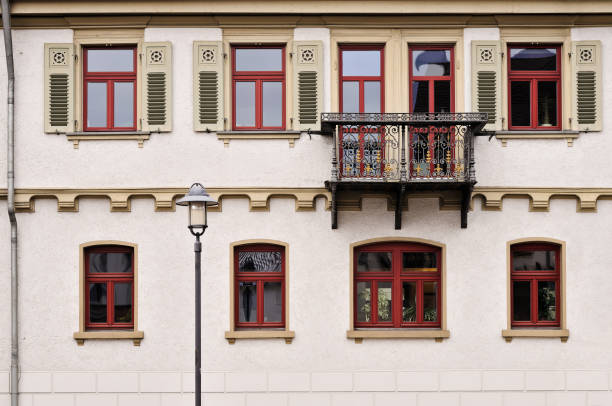 A person with a dog sitting on a balcony overlooking city with red windows