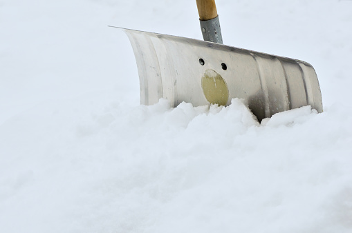 A Snow shovel stuck in a snowbank