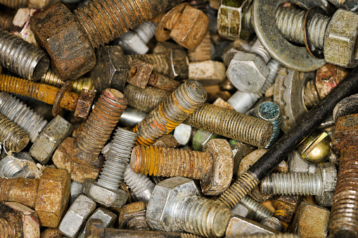 Assorted screws and nuts stacked together in a close-up view