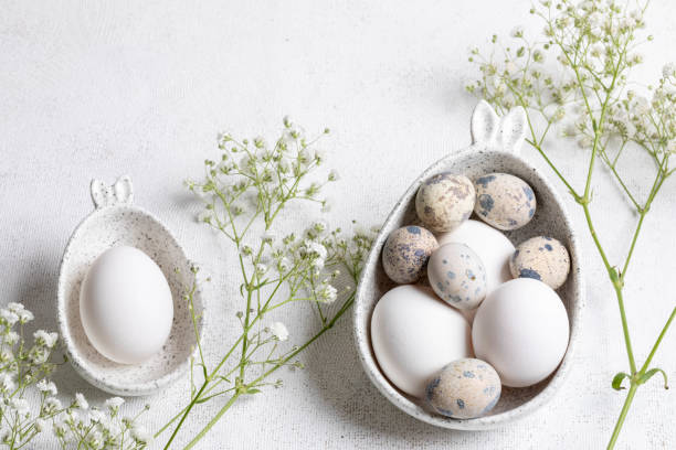 istock Organic Easter. Two figured marble bowls with eggs, Gypsophila twigs on white. Top view. 2062941541