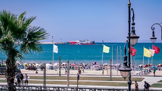 Tanger, Morocco – July 20, 2023: A crowded beach on a sunny day with people enjoying the ocean in Tanger, Morocco