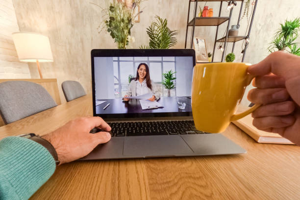 istock Young Man Having A Video Conference While Working At The Kitchen Table At Home 2062954683