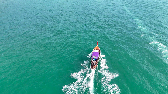 A boat sailing in the turquoise waters of the Andaman Sea. Thailand