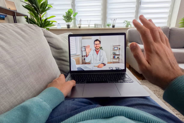 istock Young Man Having A Doctor's Appointment Online Using Laptop On The Sofa At Home 2062956300