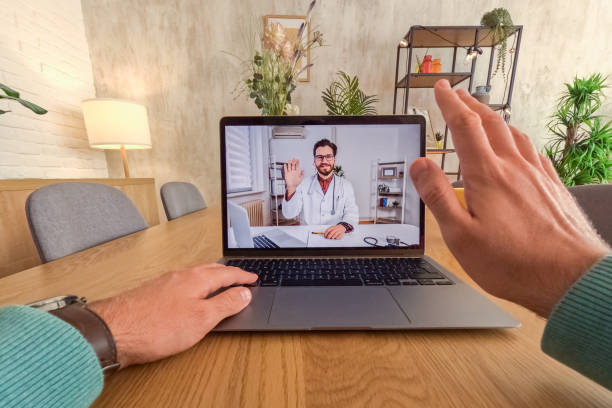 istock Young Man Having A Doctor's Appointment Online Using Laptop At The Kitchen Table At Home 2062968996