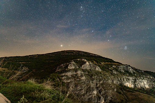 Stars above the hill in a night sky.