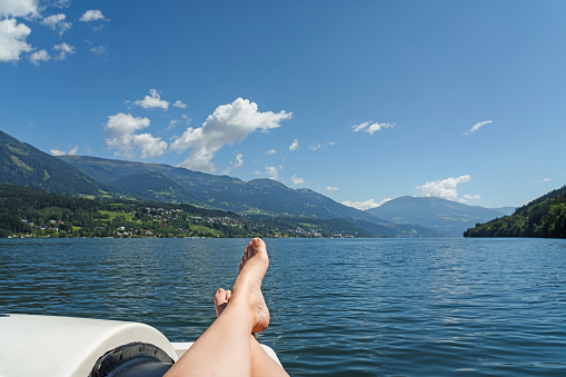Stretch your feet in a relaxed manner on vacation. Water at the mountain lake.
