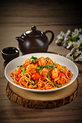 traditional chinese wok stir fried bee hoon noodle spicy chilli mee goreng with clam prawn seafood in plate on grey vintage background cafe hotel luxury halal food restaurant banquet menu