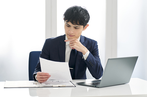 Asian businessman examining work documents