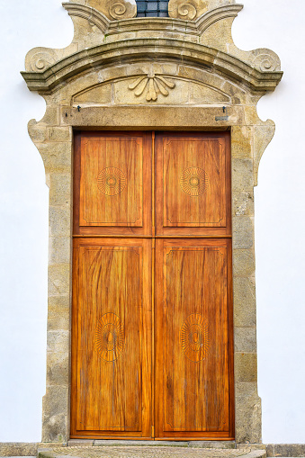 A vertical of an old wooden door with rivets and metal screws