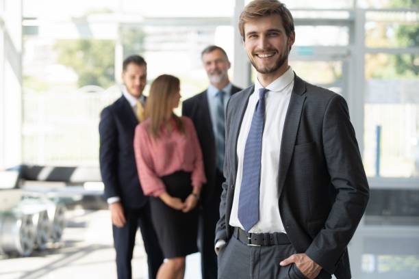 istock Team leader stands with coworkers in background 2063067734
