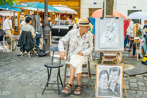Paris, France - September 10, 2023 : Old caricaturist on Place du Tertre in Montmatre in Paris, France