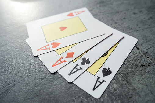 Four aces playing cards on grey desk. Gambling concept