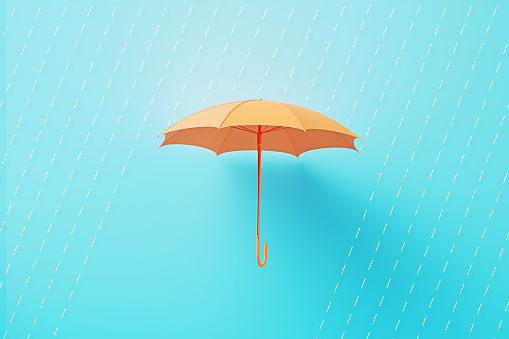 Rain drops over orange colored umbrella on blue background. Horizontal composition.