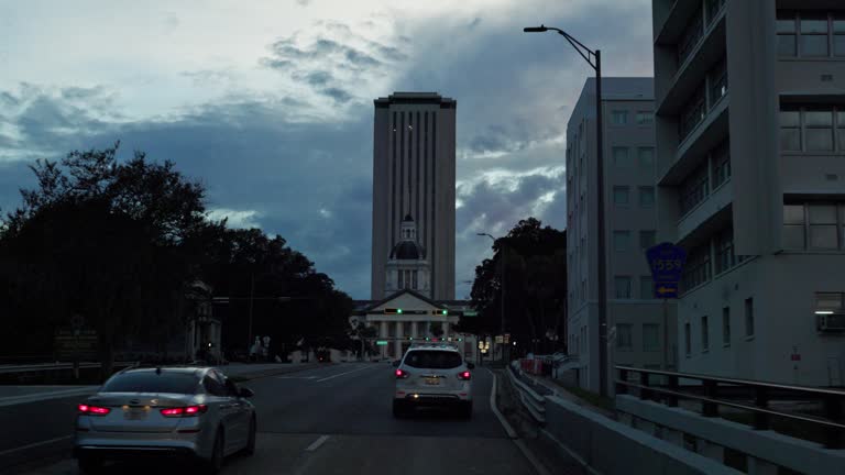 Downtown Tallahassee, FL: Apalachee parkway drive to Florida State Capitol in the evening. POV of car