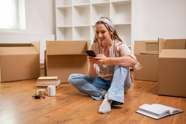 istock Happy ginger woman using phone in her new home 2063102354
