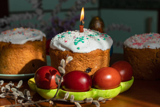 Elegant Easter cakes with burning candles on the dining table