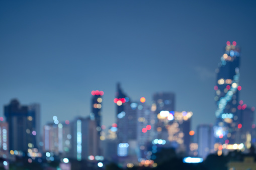 Abstract blurred background cityscape of Krung Thep Maha Nakhon (Bangkok) on night scene with multicolour bokeh from neon light on building