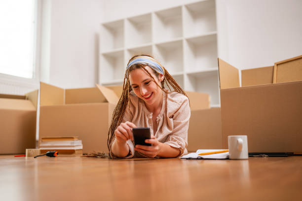 istock Happy ginger woman using phone in her new home 2063106128