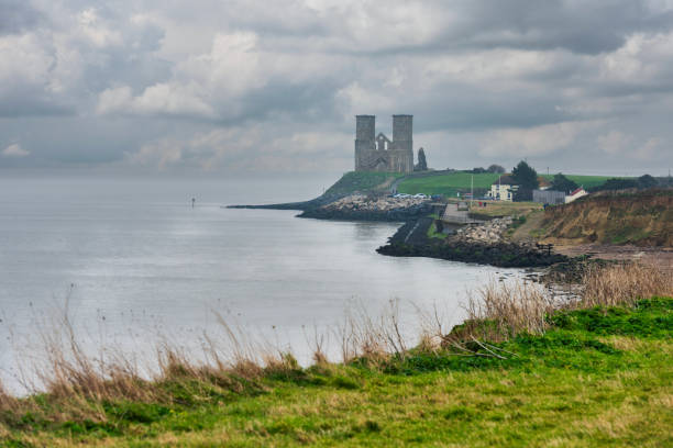 reculver towers in kent, england viewed from the coastal path between reculver and herne bay - herne bay стоковые фото и изображения