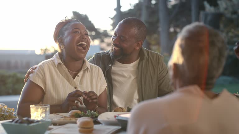 Talking, hug or black family in home with lunch to celebrate in group reunion, feast or social event. Funny man, woman laughing or happy people with parents, smile or love at dinner, meal or brunch