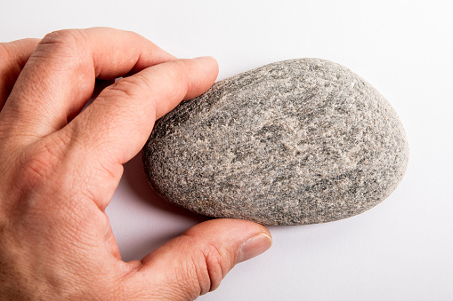 Flat stone in hand on white background.